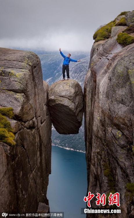 挪威游客冒雨登千米高悬石拍照