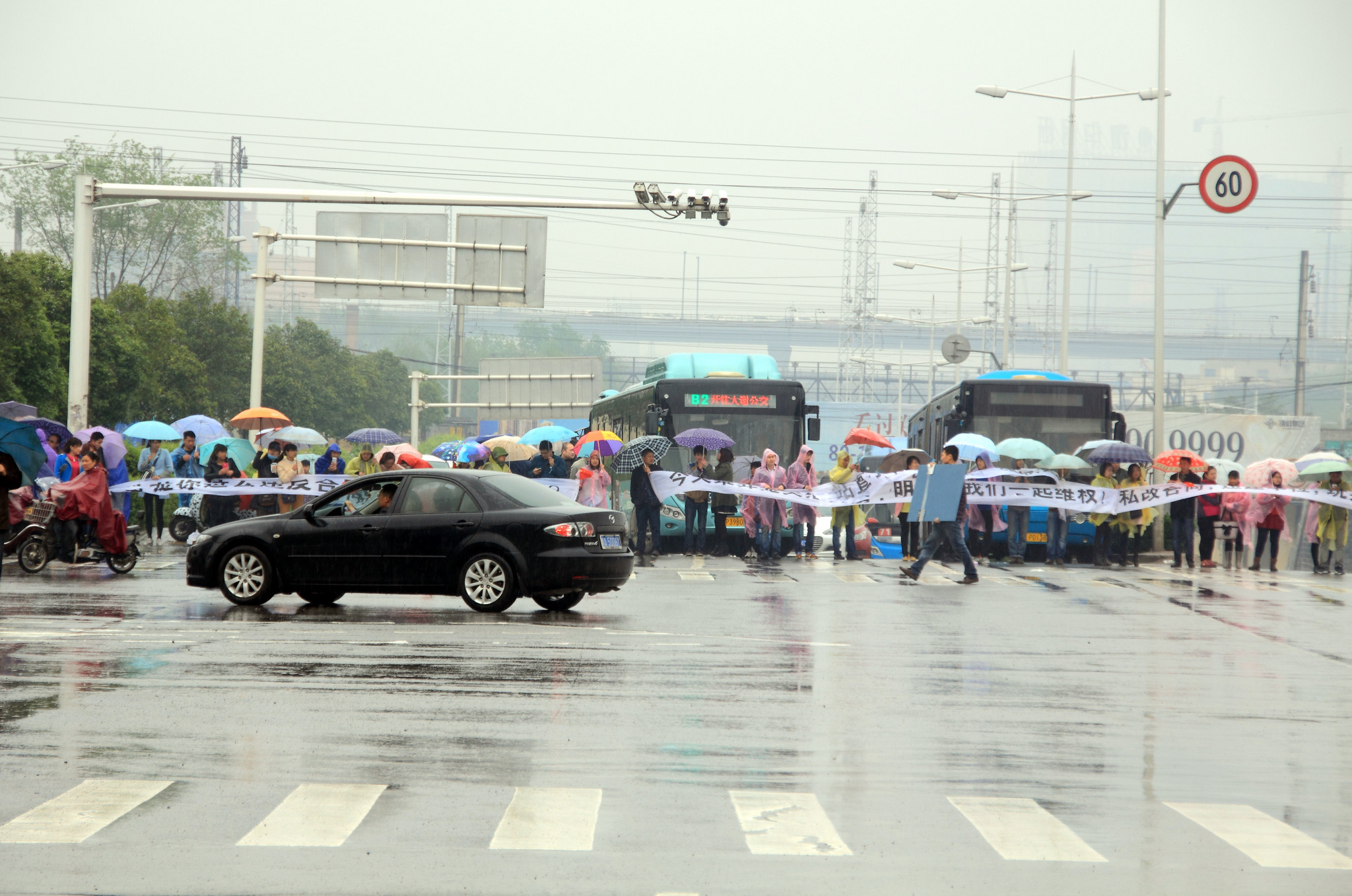 郑州一小区业主雨中排人墙“维权” 致交通瘫痪