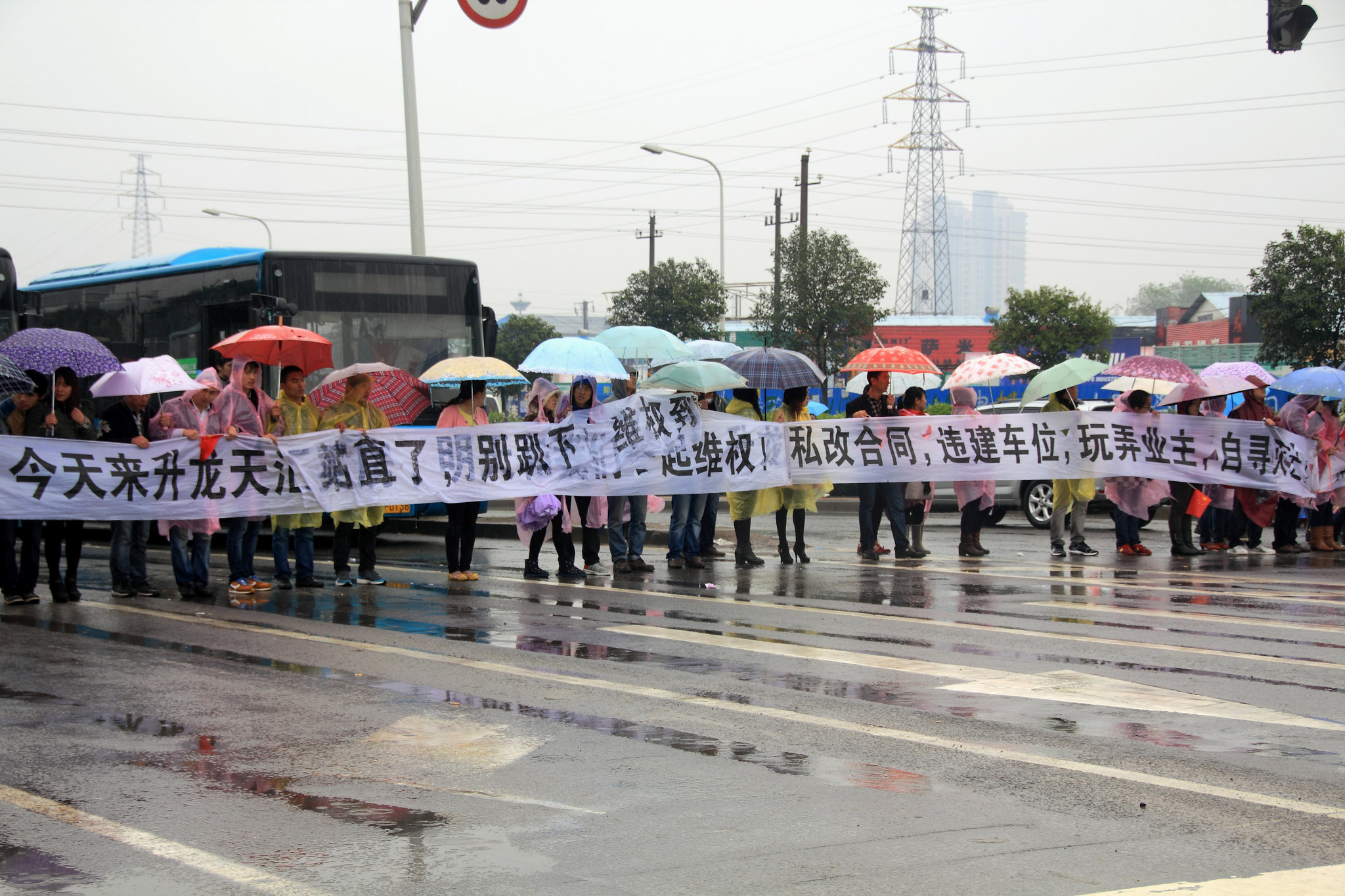 郑州一小区业主雨中排人墙“维权” 致交通瘫痪