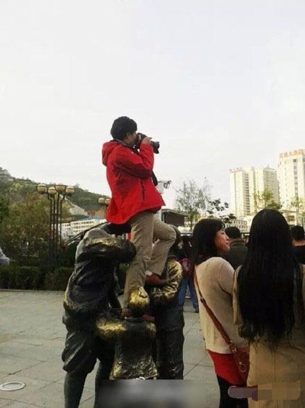 延安一女子为拍照坐红军雕塑头上