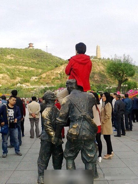 延安一女子为拍照坐红军雕塑头上