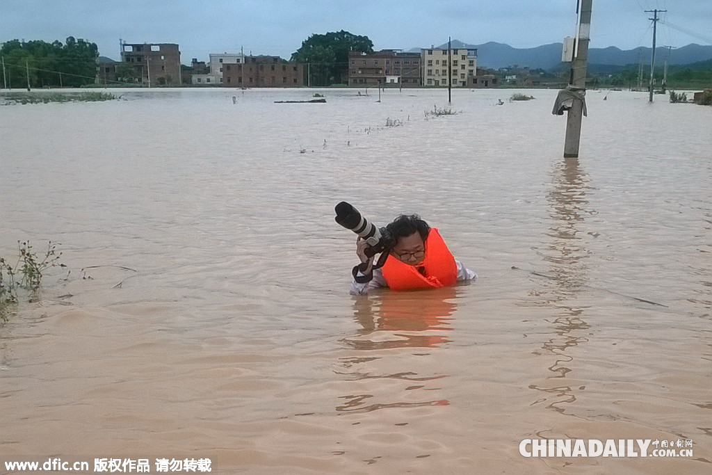 江西赣州：记者半身淹没洪水中拍照“蛮拼的”
