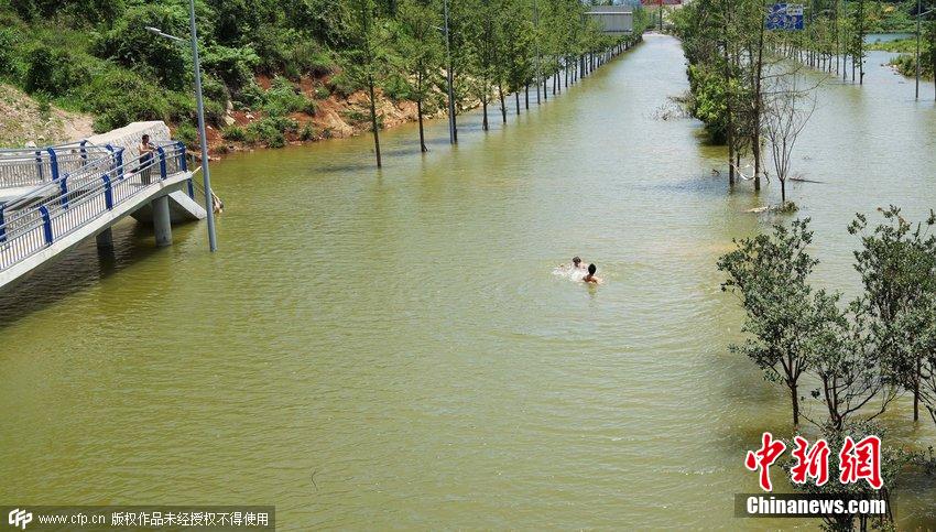 街道因大雨积水严重 市民享受天然“泳池”
