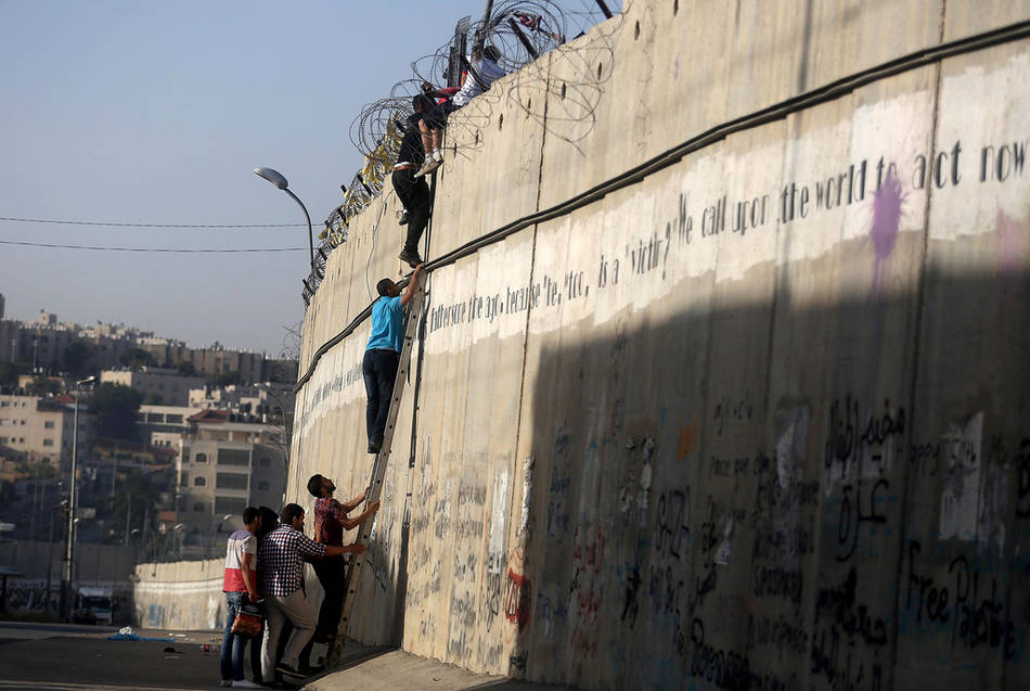 为了祷告 巴勒斯坦青年攀爬翻越隔离墙