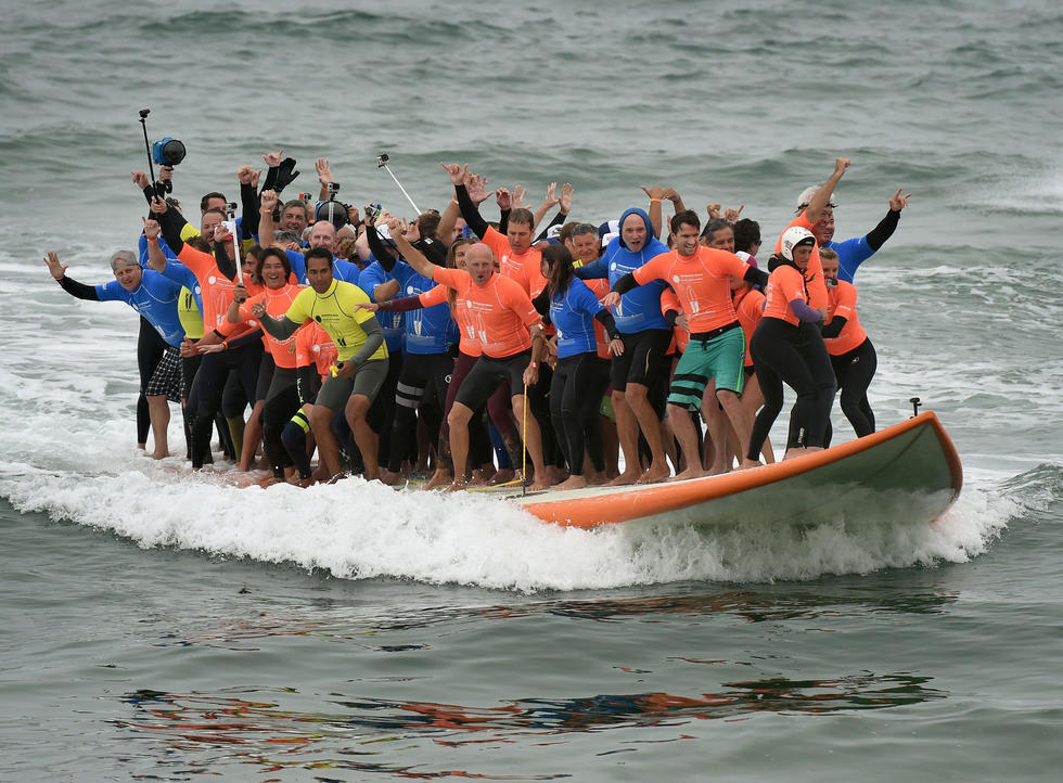 美国66人登一块滑板玩冲浪打破世界纪录