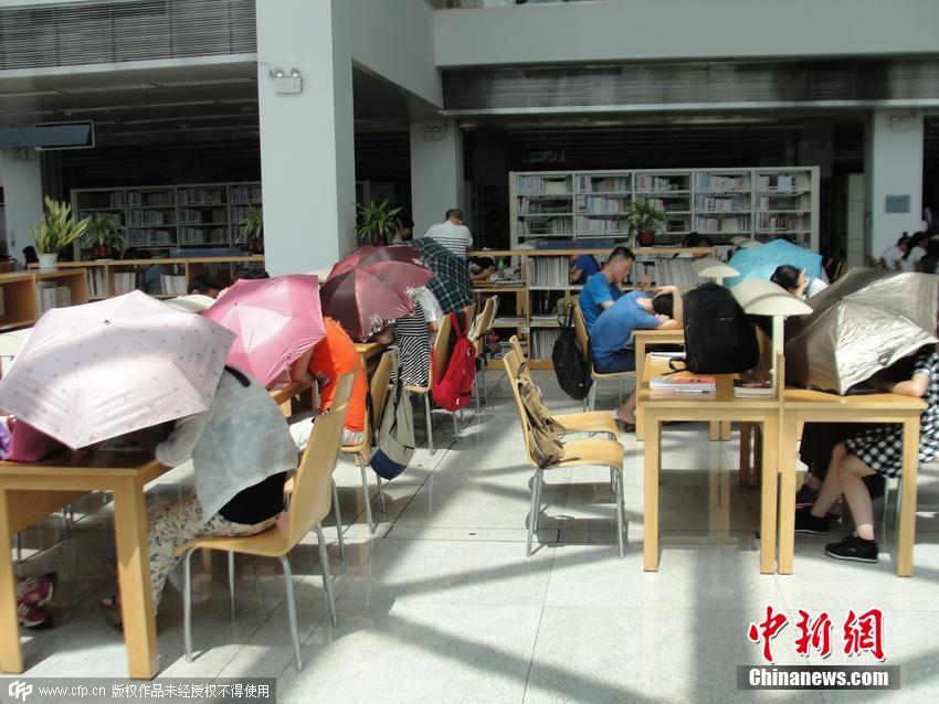 深圳图书馆内太阳暴晒 民众撑伞读书