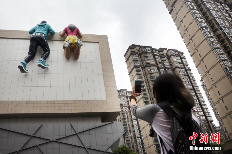 “巨人”雕塑趴常州高楼 独特造型引路人围观