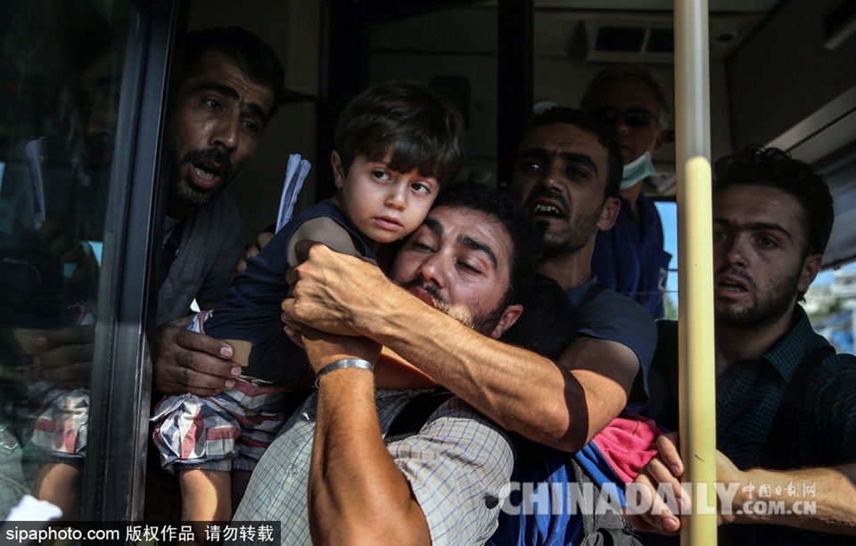 2500名移民抵达希腊港口 双手比“V”庆祝