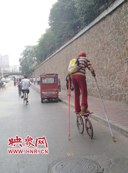 郑州街头现任性滑车哥 持2米长杆如玩杂技