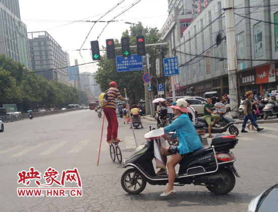郑州街头现任性滑车哥 持2米长杆如玩杂技