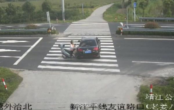 女子骑车玩手机 被轿车撞飞