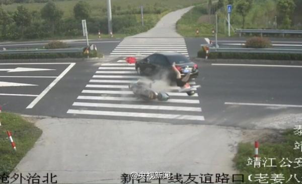 女子骑车玩手机 被轿车撞飞