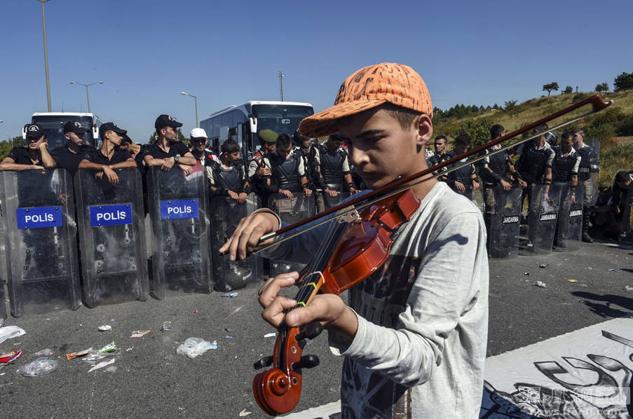 13岁难民警察盾牌阵前拉小提琴
