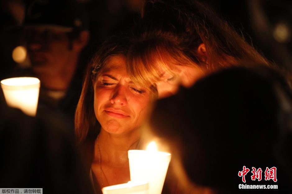 美国民众点燃烛火 悼念校园枪击案遇难者