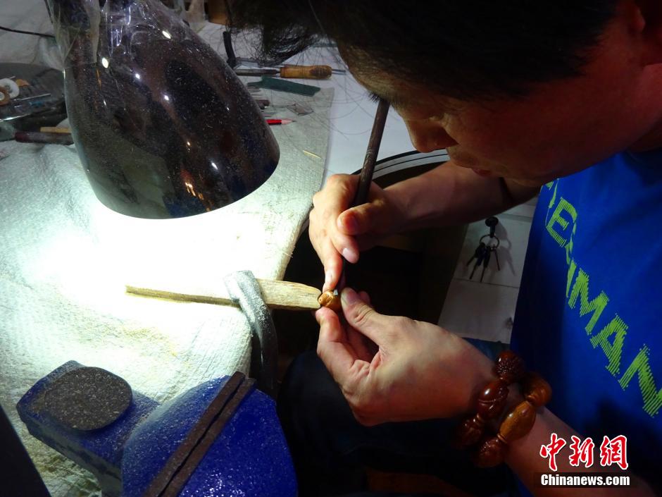 郑州核雕艺人橄榄核上展现“双面十八罗汉”