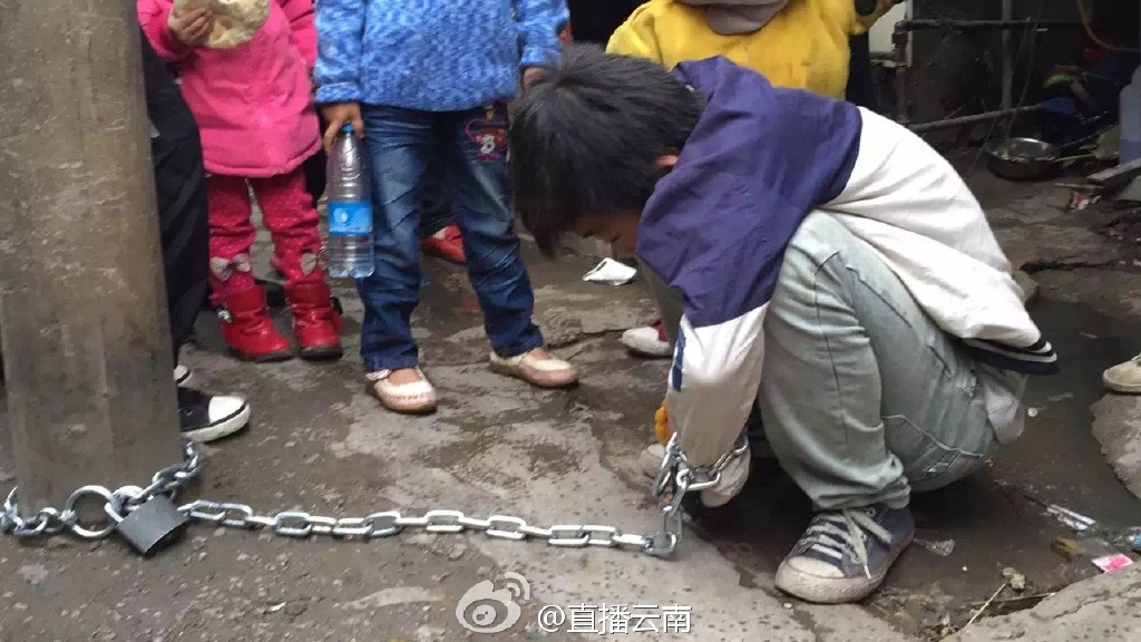 熊孩子被亲妈用铁链锁街头电线杆示众