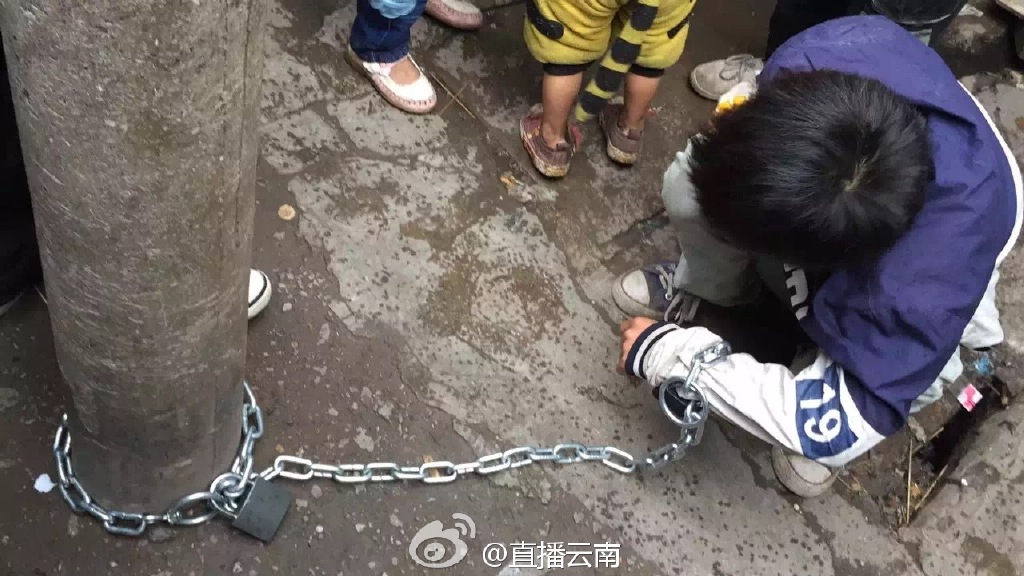 熊孩子被亲妈用铁链锁街头电线杆示众