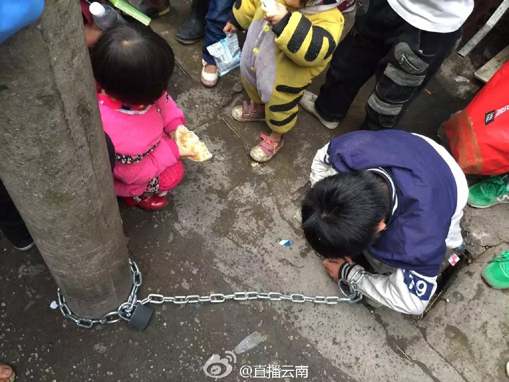 熊孩子被亲妈用铁链锁街头电线杆示众