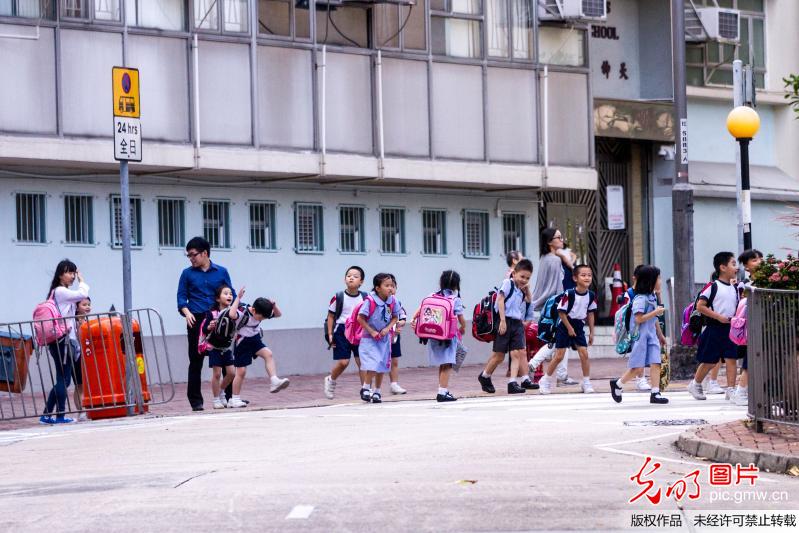 香港：小学生功课负担沉重 家长陪伴上学帮背书包