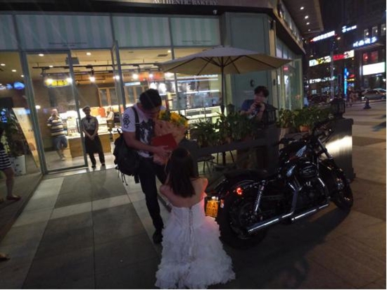 90后美女骑摩托车拿房产证 街头上演浪漫求婚