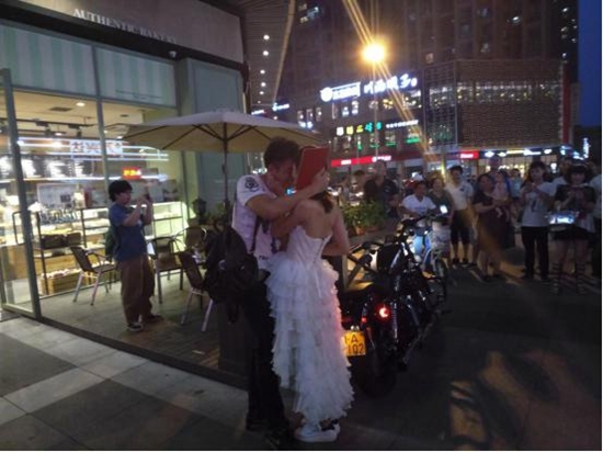 90后美女骑摩托车拿房产证 街头上演浪漫求婚