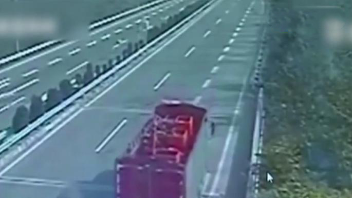 货车高速上违规倒车 女子用身体遮车牌躲监控