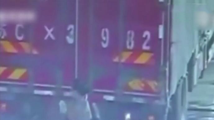 货车高速上违规倒车 女子用身体遮车牌躲监控