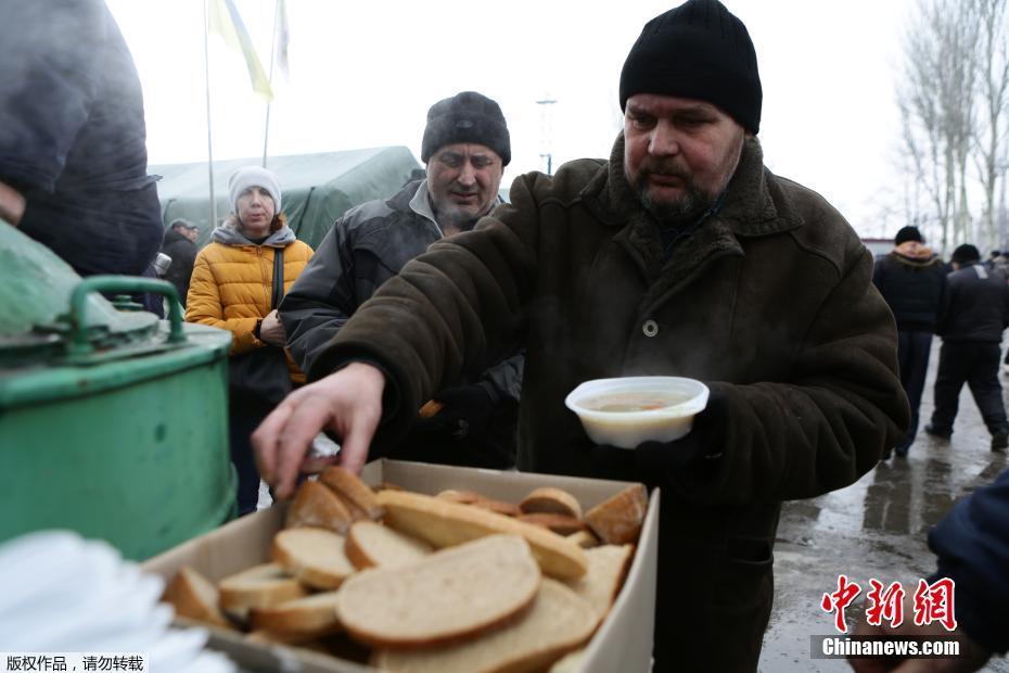 乌克兰东部冲突地区平民排队领取食物