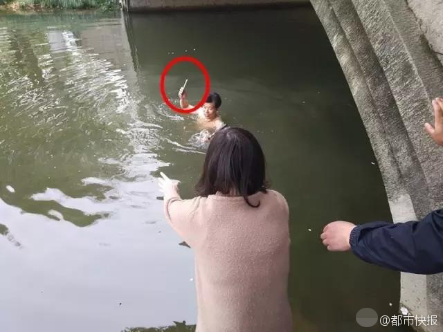 女生拍毕业照手机掉水里 保安脱衣下水捞