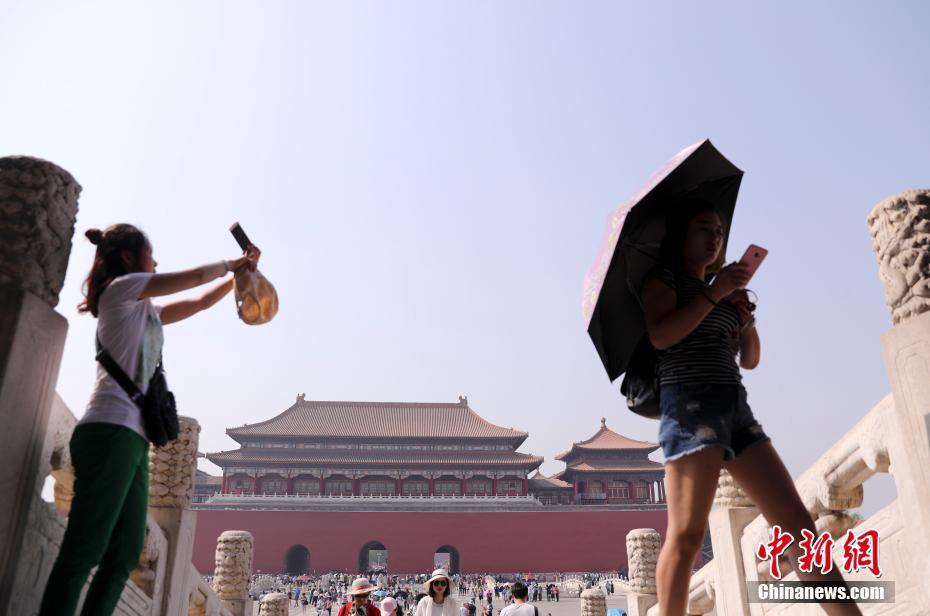 北京持续高温 故宫游客撑伞防晒