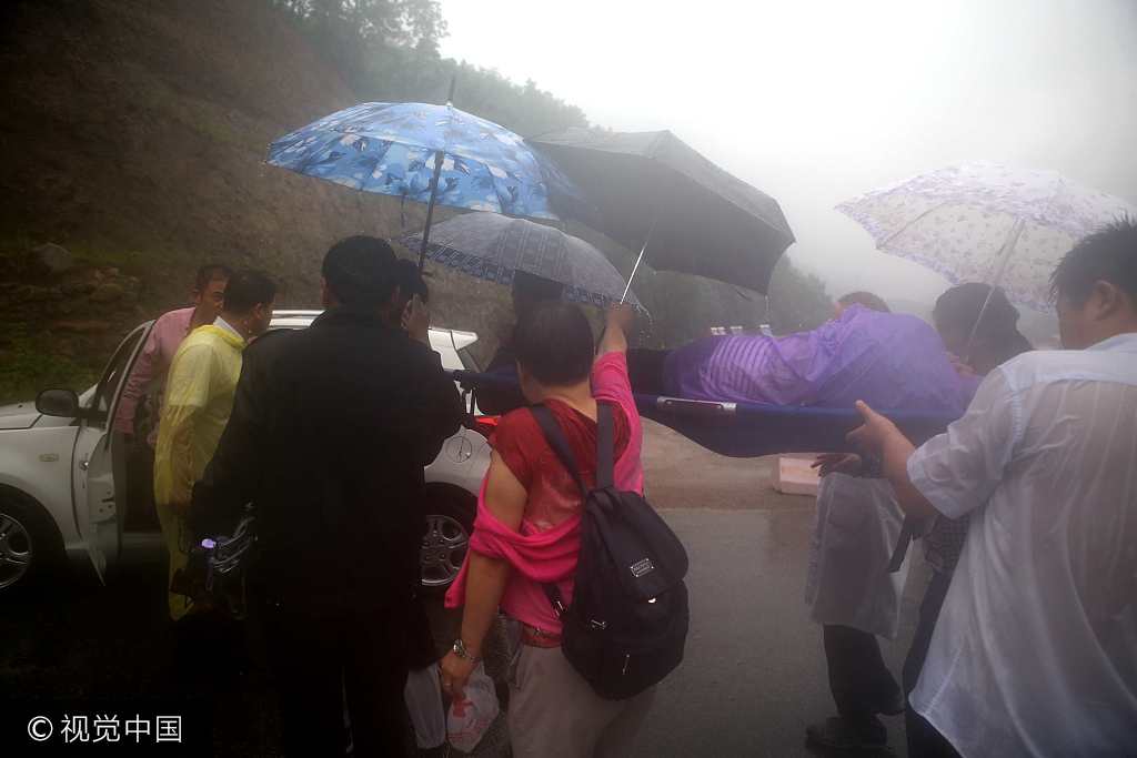 女游客突发疾病 道士深山冒雨抬担架救人