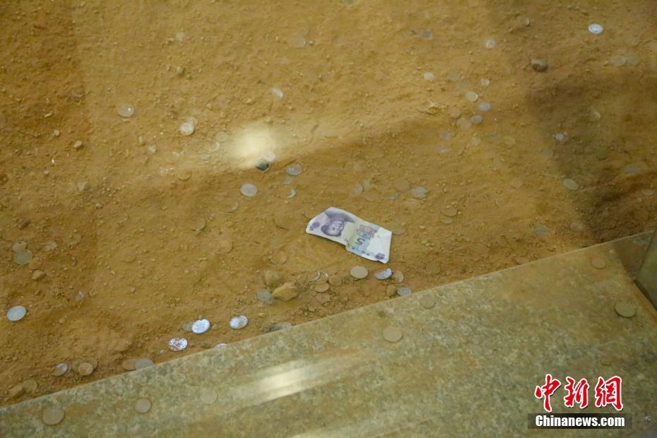 杭州雷峰塔遗址被游客扔成“钱山”