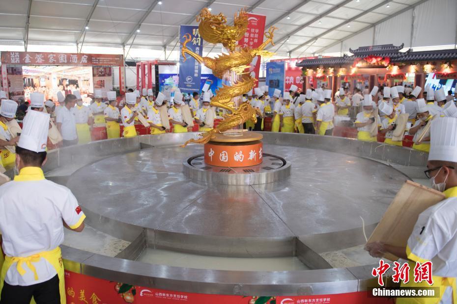 厨师用“世界第一锅”下刀削面 展示山西面食文化