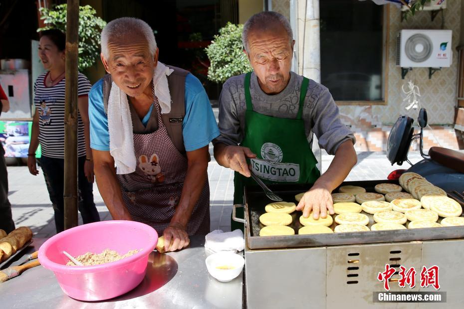 陕北老哥俩西安街头做“土月饼”十余年 日售300个