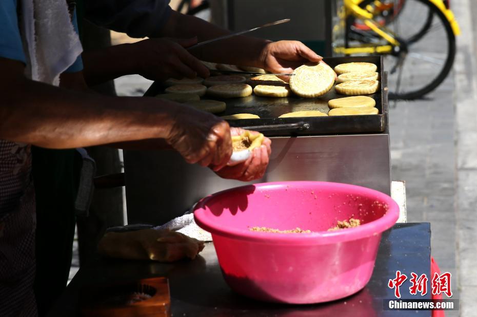 陕北老哥俩西安街头做“土月饼”十余年 日售300个
