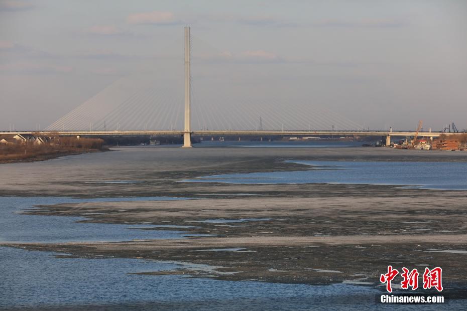 哈尔滨现“半江流水半江冰”