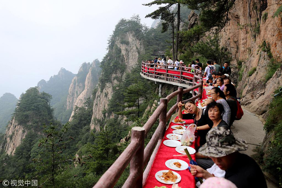 河南洛阳：悬崖边摆“云海盛宴”蜿蜒数百米 民众云雾中吃山珍海味