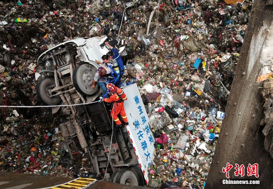 垃圾回收车掉入坑底 消防官兵戴空气呼吸器救